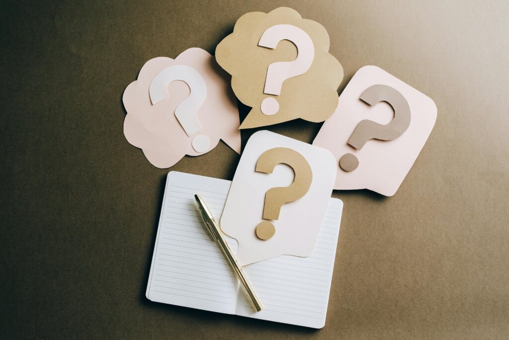 pexels-photo-5428830-5428830 Flat lay of question mark paper crafts on a notebook, symbolizing questions and ideas.